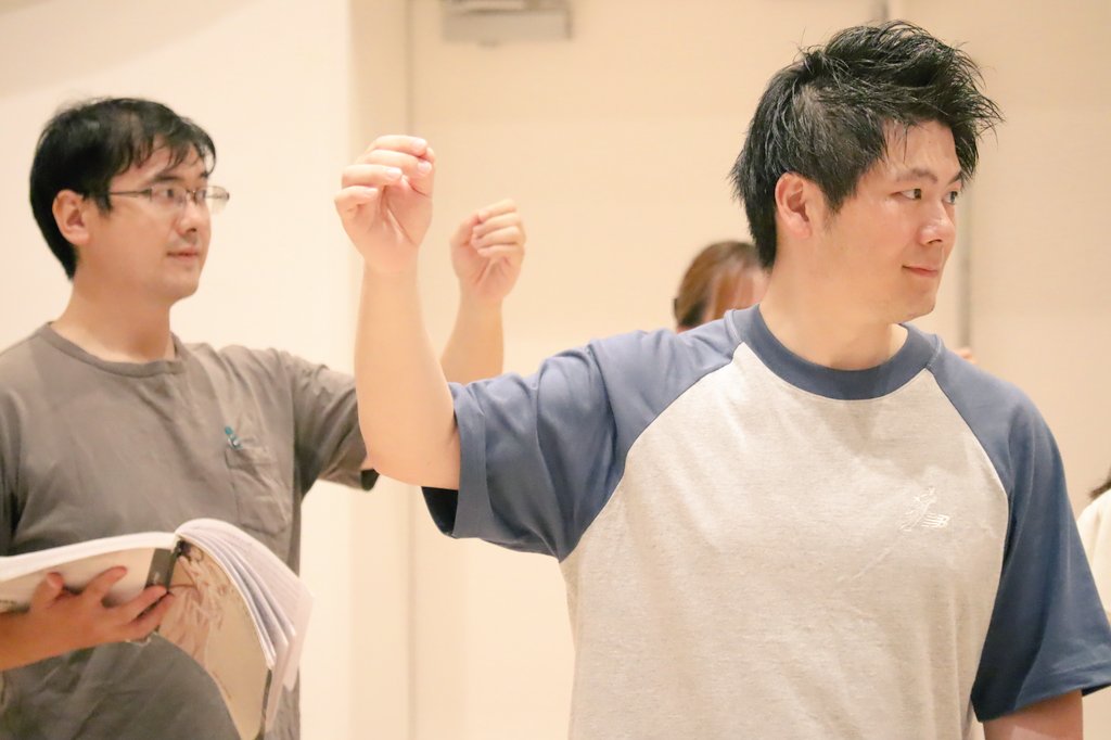 手をかかげて乾杯の演技をする歌手青山航と島崎昭之助