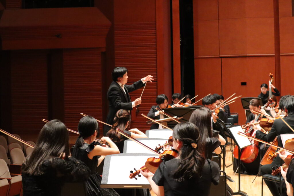 オーケストラの前で指揮を振る指揮者濱本広洋